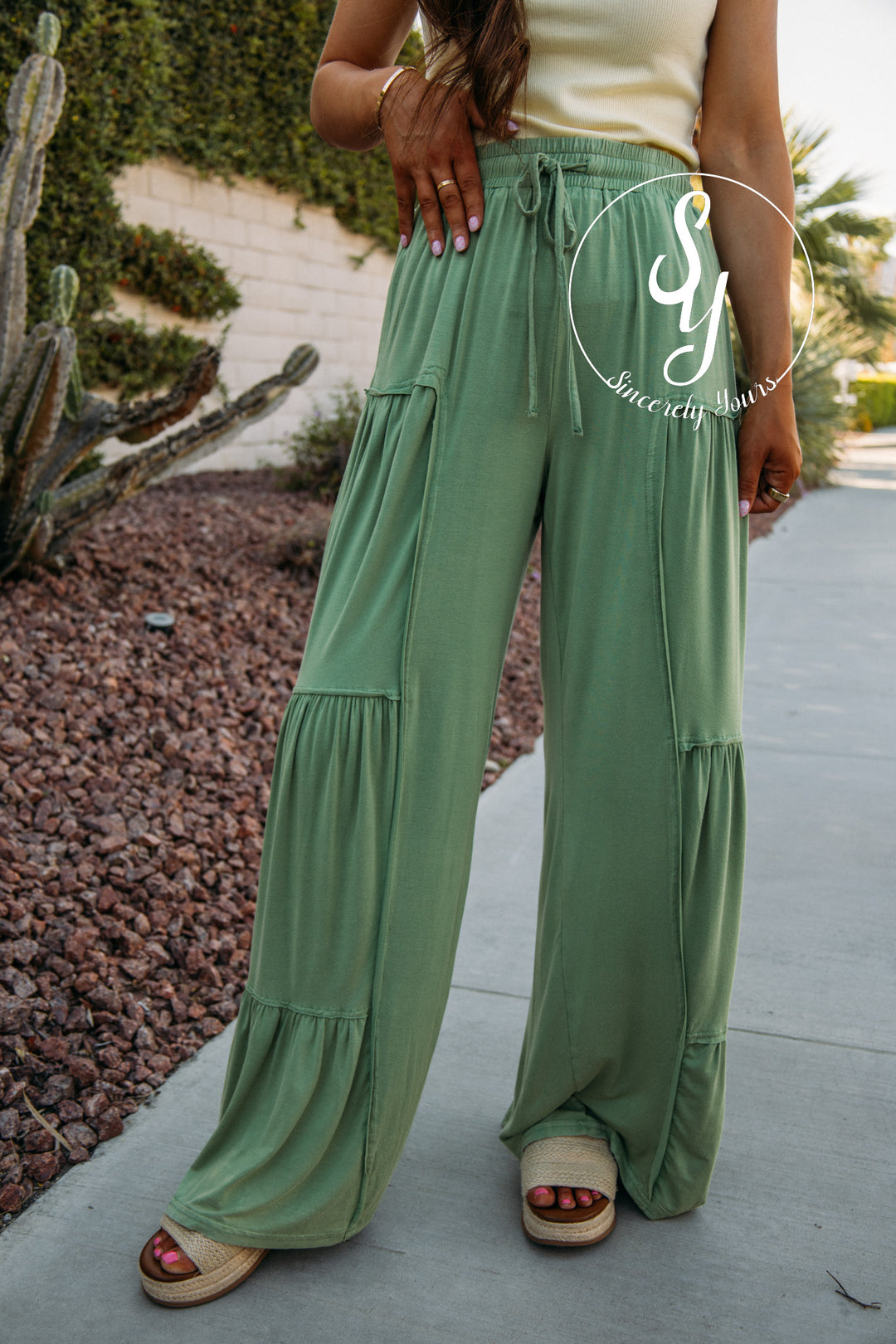 Person wearing green wide-leg pants with a blurred background