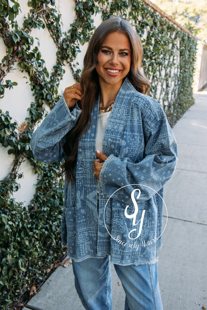 Woman wearing a denim jacket with a brand logo in the corner