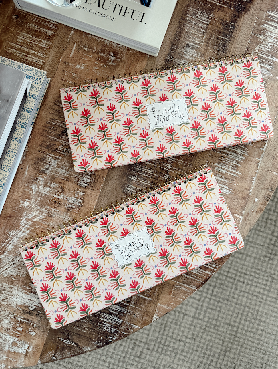 Two patterned notebooks/weekly planner on a textured surface 
