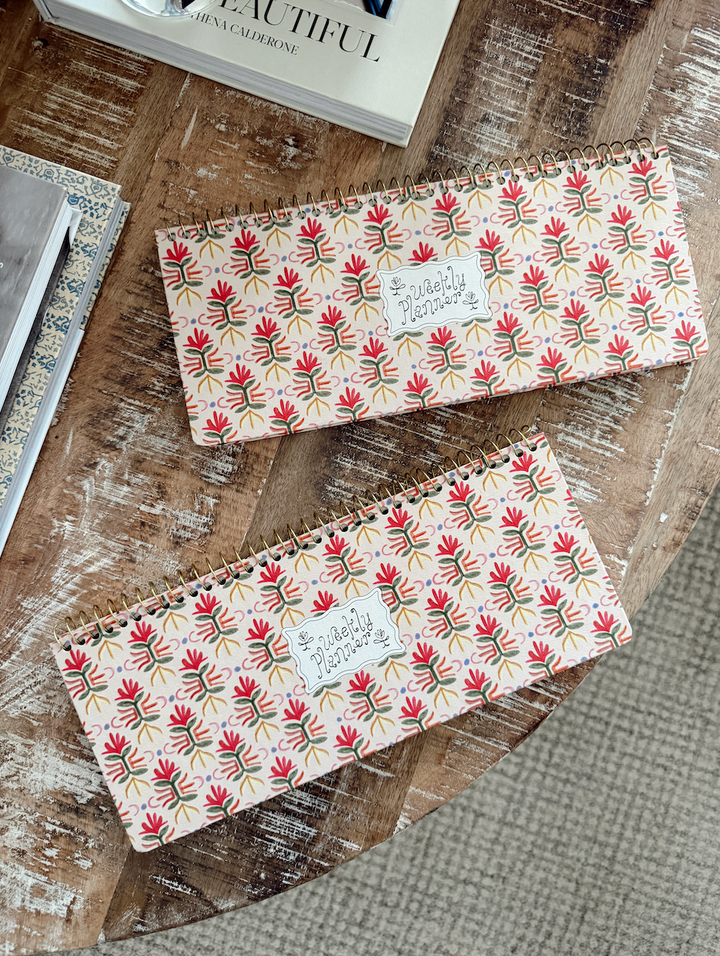Two patterned notebooks/weekly planner on a textured surface 
