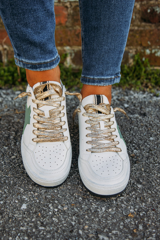 A classic shoe that is a staple! The white Paz Sneaker features a green star and gold sparkle heel tab. So trendy and super comfortable for everyday wear! These are perfect for a casual day of running errands or super cute dressed up for a casual date!